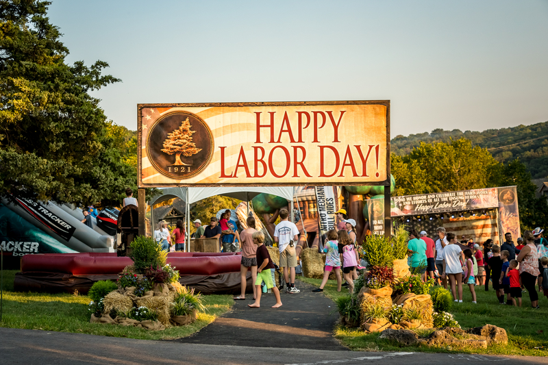 Labor Day sign with family and friends enjoying activities