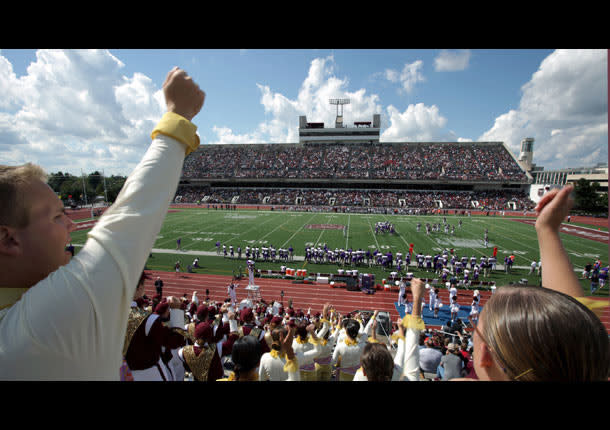 A group cheers with raised hands at t football game overlooking Plater Stadium where an MSU home football game is taking place.