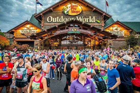 A large group of people gather in front of the Bass Pro Shops Grand Daddy Store in Springfield Missouri dressed in athletic running attire