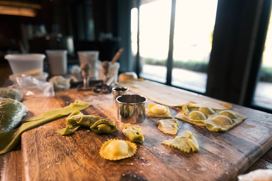 a large wooden table with an assortment of fresh stuffed pastas